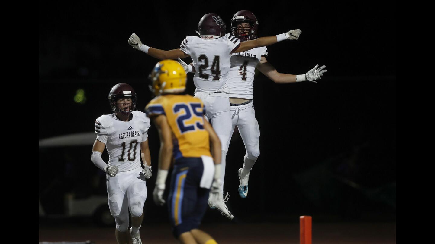 Laguna Beach High Sean Nolan (4) celebrates his first touchdown with wide receiver Kai Ball (24) during the first half against Marina in a nonleague game at Westminster High on Friday, Sept. 28.