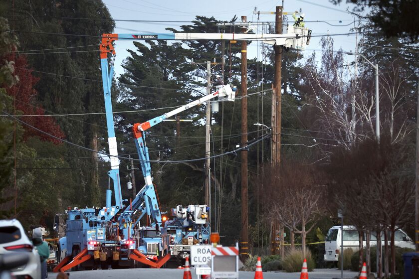PG&E workers toil in the evening above Highland Avenue to replace equipment damaged by high winds in Santa Cruz, Calif., Tuesday, Jan. 10, 2023. (Shmuel Thaler/The Santa Cruz Sentinel via AP)