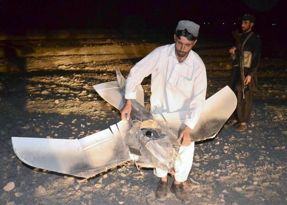 A Pakistani villager holds a wreckage of a suspected surveillance drone that crashed in Pakistan last August.
