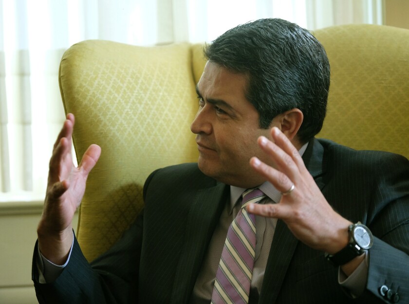 Honduras President Juan Orlando Hernandez speaks with Texas Gov. Greg Abbott during a meeting at the governor's mansion in Austin, Texas, on Thursday.