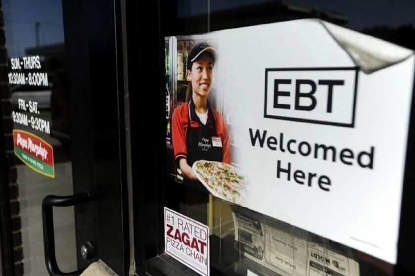 On Friday, the federal government rolled back Food Stamp benefits for all 48 million people who receive them. Above, a sign notifies customers that EBT can be used at a store in Sioux Falls, S.D.