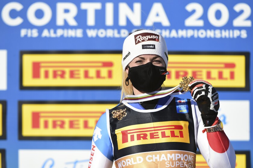 Switzerland's Lara Gut-Behrami shows her gold medal for the women's super-G, at the alpine ski World Championships, in Cortina d'Ampezzo, Italy, Thursday, Feb. 11, 2021. (AP Photo/Marco Tacca)