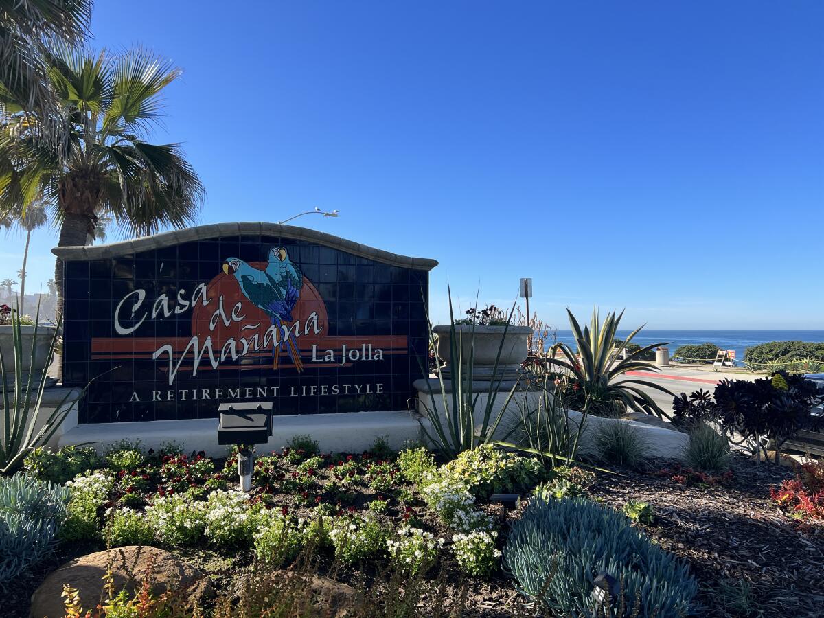 A sign reads "Casa de Mañana La Jolla A Retirement Community" in front of ocean view 