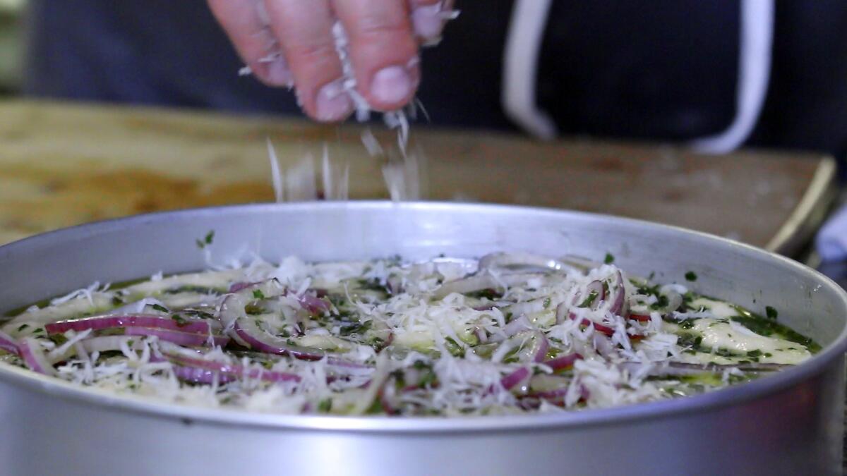 Step 5: Add toppings like sliced red onions and grated Parmesan cheese.