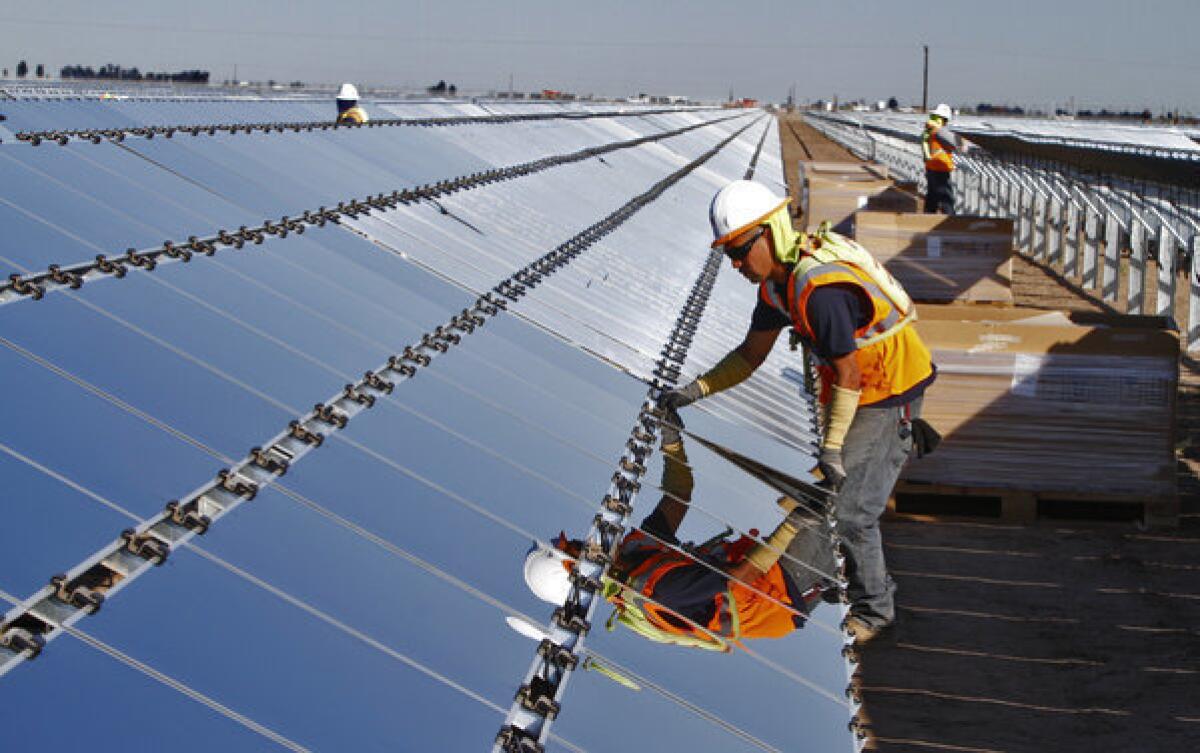 In 2011, U.S. firms held a $1.63 billion trade surplus with China in clean energy goods. Above, a worker installs a photovoltaic panel at the Tenaska Imperial Solar Energy South project in the Imperial Valley west of El Centro, Calif., last month.