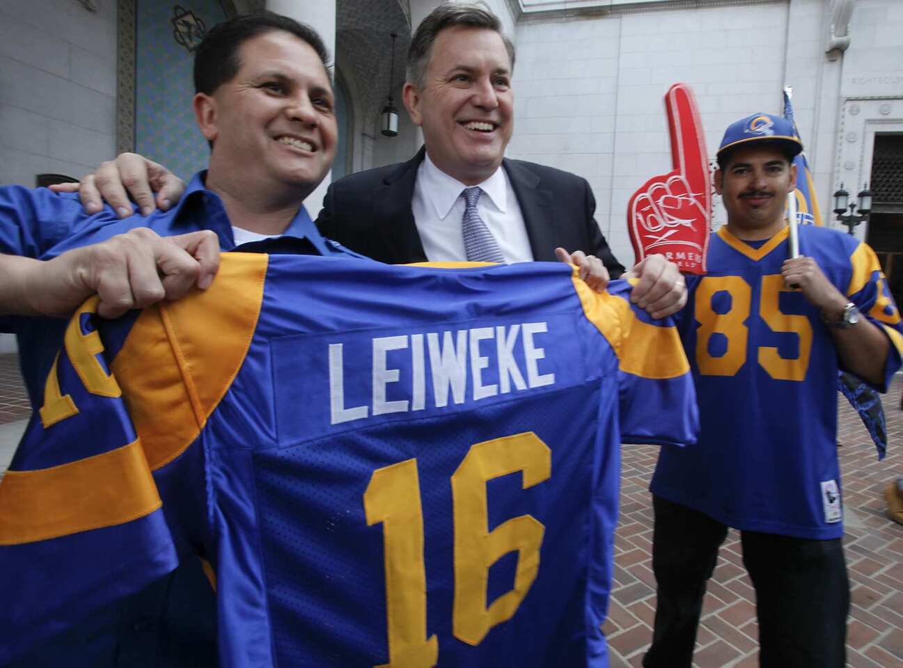 Tom Bateman of Bring Back the Rams presents a jersey to Tim Leiweke, president of Anschutz Entertainment Group, to celebrate the delivery of a $27-million environmental impact report on a downtown football stadium that Anschutz hopes to build to bring the NFL back to Los Angeles.