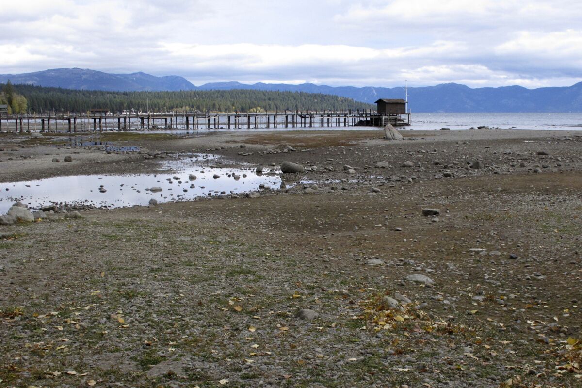 FILE - A pier and dock sits above Lake Tahoe's receding shoreline Wednesday, Oct. 20, 2021 at Tahoe City, Calif. There’s no relief in sight for the West’s record-shattering megadrought, which will likely only deepen this spring, the National Oceanic and Atmospheric Administration said in its seasonal outlook Thursday, March 17, 2022. But central and eastern states should be mostly spared from significant flooding. (AP Photo/Scott Sonner, File)