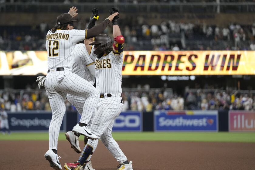 San Diego Padres' Jorge Alfaro, right, celebrates with teammates, including Luis Campusano, front left, after the Padres defeated the Los Angeles Dodgers 4-3 in 10 innings in a a baseball game Tuesday, Sept. 27, 2022, in San Diego. (AP Photo/Gregory Bull)