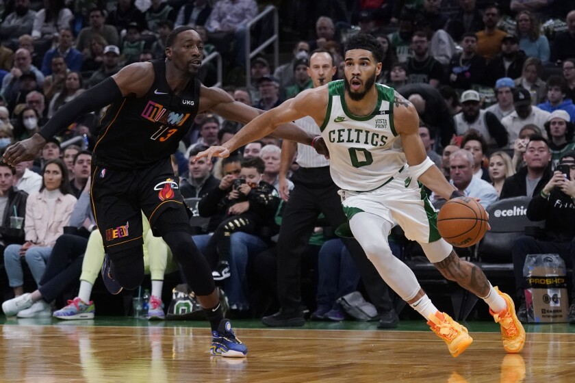 Boston Celtics forward Jayson Tatum (0) drives to the basket against Miami Heat center Bam Adebayo (13) during the first half of an NBA basketball game, Wednesday, March 30, 2022, in Boston. (AP Photo/Charles Krupa)