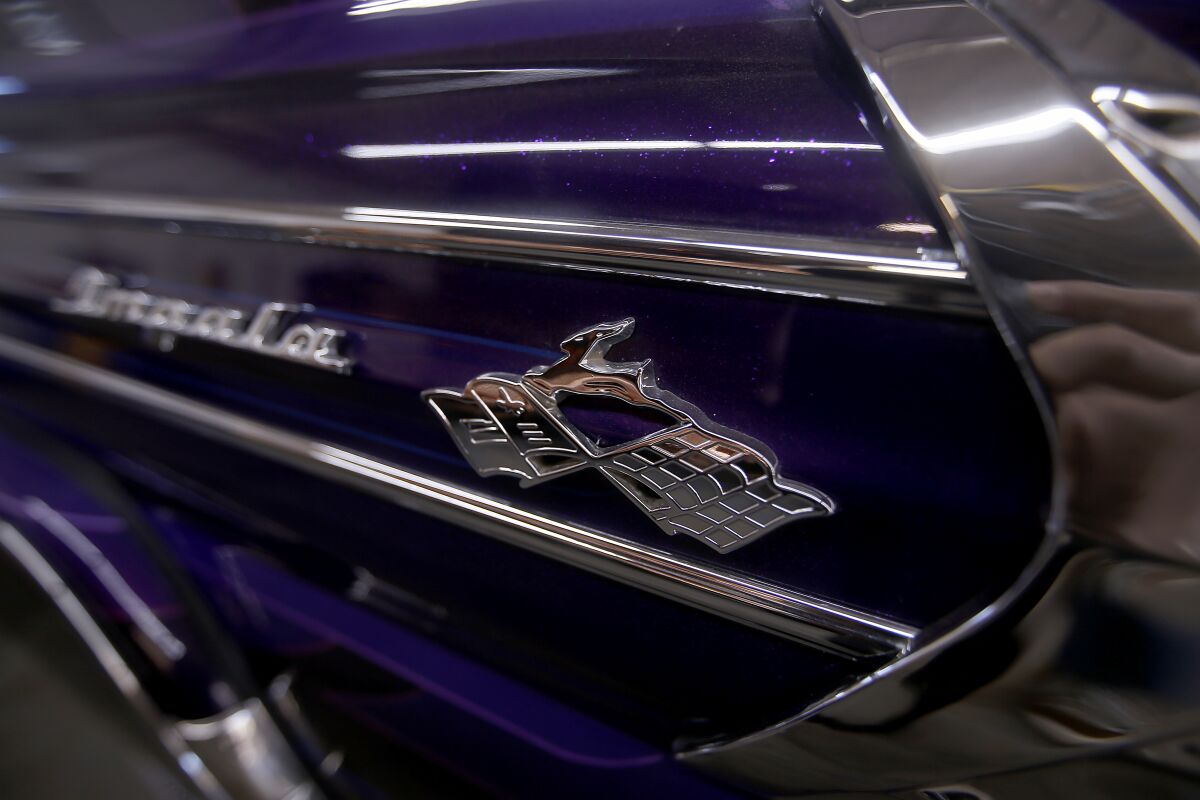 A chrome Chevrolet Impala badge on a dark blue muscle car
