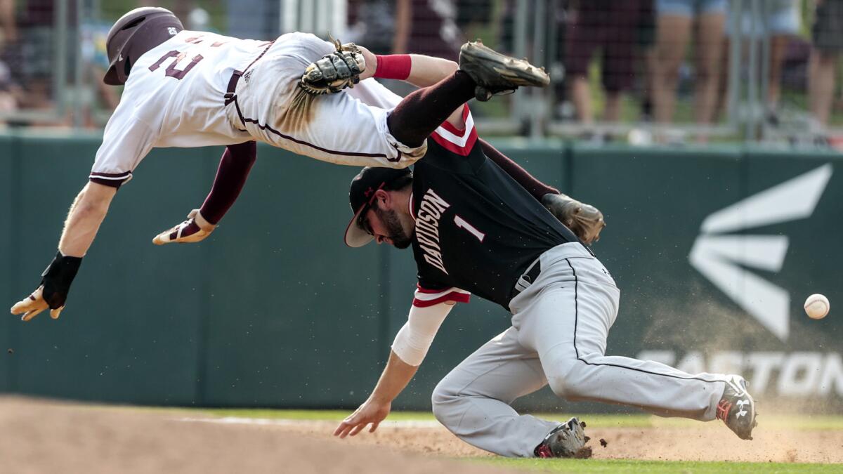 Texas A&M's Austin Homan collides with Davidson infielder Tyler Agard while trying to advance on a grounder in the 12th inning. Homan was called out for interference on the play.