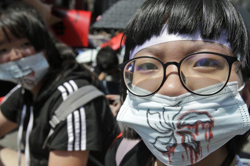 Hong Kong protest supporters in Taipei, Taiwan, wear masks depicting bloody flowers.