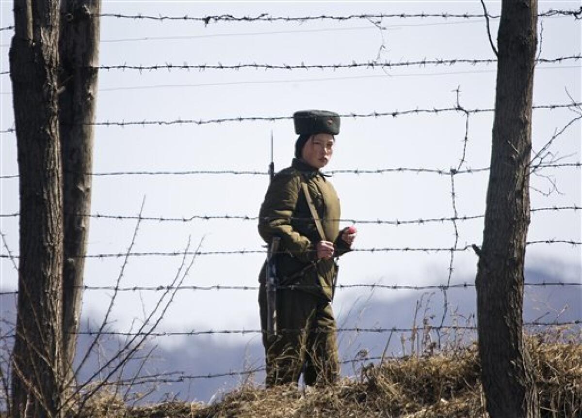 A North Korean female soldier looks on as she stands guard along the waterfront of the Yalu River at the North Korean side, opposite side of the Chinese border town of Hekou, northeast of Dandong, China, Monday, March 23, 2009. Two American journalists detained by North Korean soldiers after they "illegally intruding" in its territory after crossing the border from China, and are believed to have been sent to Pyongyang for questioning, a news report said Sunday. (AP Photo/Andy Wong)