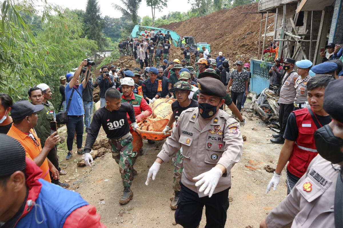 Rescuers carry a body in Indonesia.