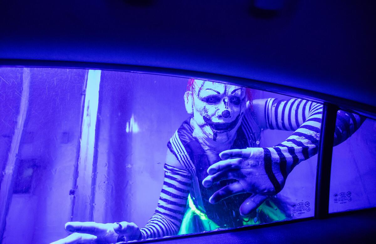 A ghoul peeks in the window at Russell Fischer Xpress Car Wash in Huntington Beach on Thursday.