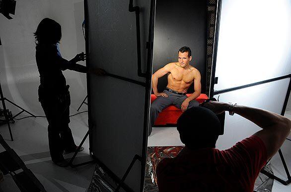 Makeup artist Justina Brittain, left, model Brandon Romain, center, and photographer Shane O'Neal, right, work in a Las Vegas studio during a photo shoot for a controversial calendar of Mormon missionaries. Chad Hardy, an entrepreneur and lapsed Mormon, has created a stir with his hunky calendar.