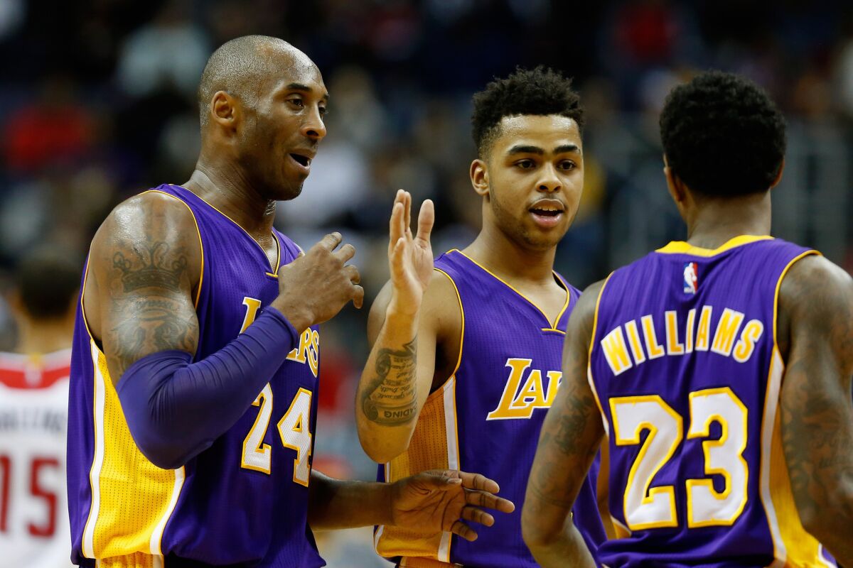 Lakers forward Kobe Bryant (24) celebrates with teammates D'Angelo Russell and Lou Williams during the second half on Wednesday.