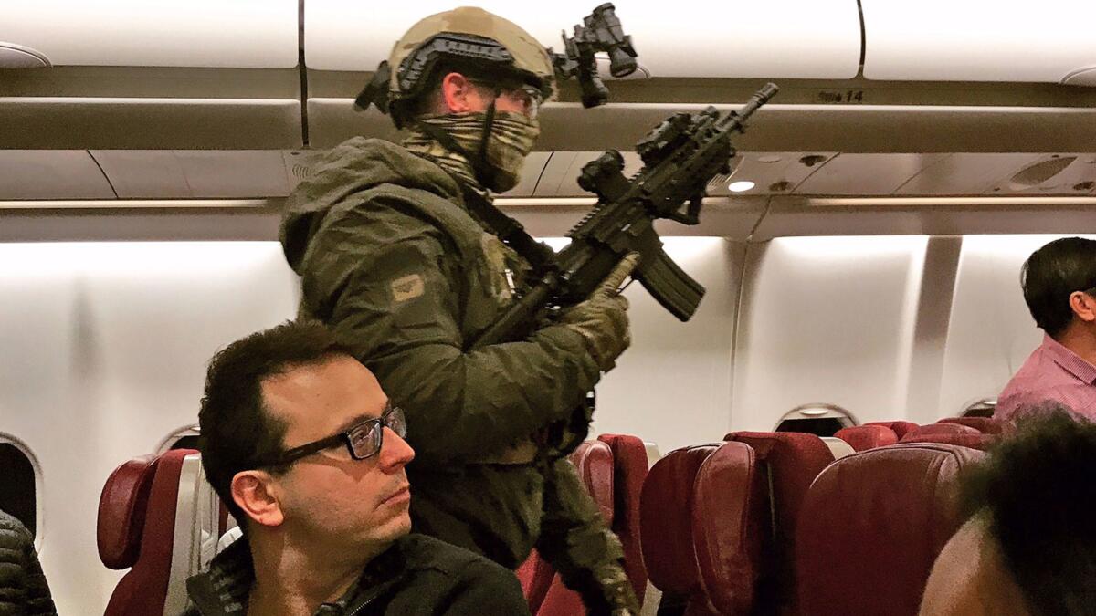 Police in tactical gear board a Malaysia Airlines plane in Melbourne after its return to Australia.