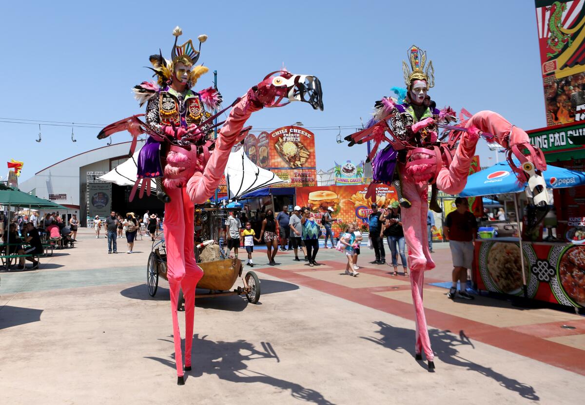 Dragon Knights performers Matt Zimmerman and Brandon Wagner perform with flamingo puppets at the O.C. Fair on Friday.