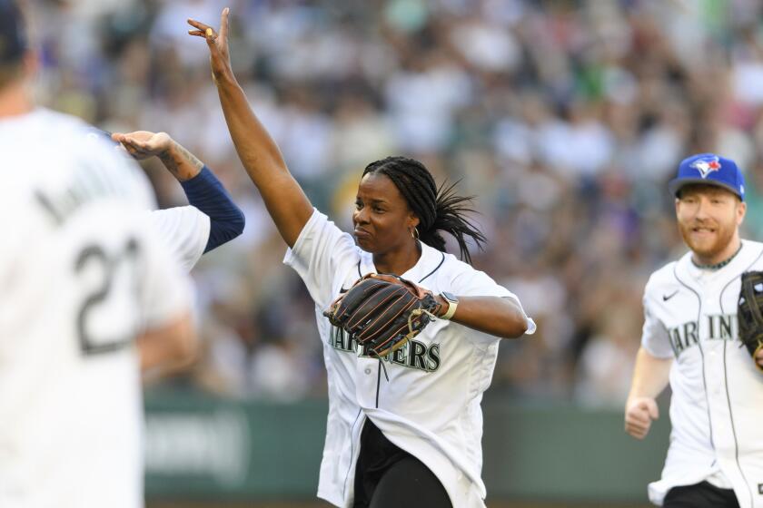 Former professional softball player and Olympian Natasha Watley smiles after catching a fly ball.