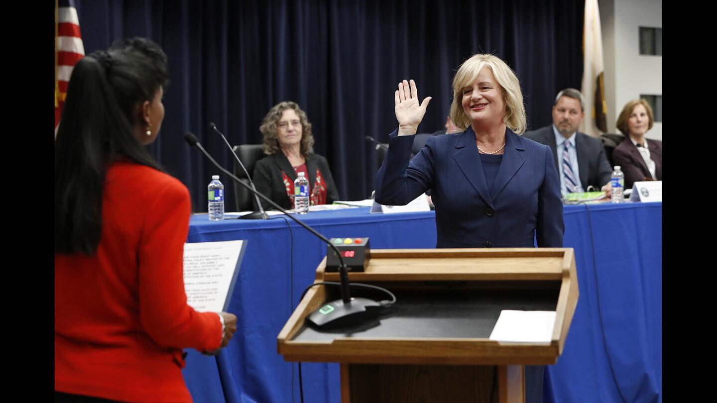 Katrina Foley, right, takes the oath of office as she is sworn in as the city's first directly elected mayor during a Costa Mesa City Council meeting held at Costa Mesa Senior Center on Tuesday, December 4, 2018. Orange County Superior Court judge Karen Robinson, left, and former Costa Mesa mayor, sworn in the council members.