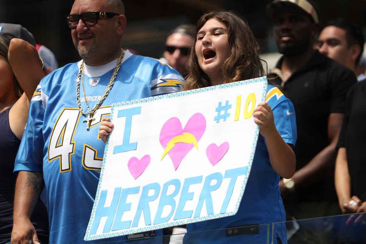 Chargers fans show their appreciation for quarterback Justin Herbert with a sign.