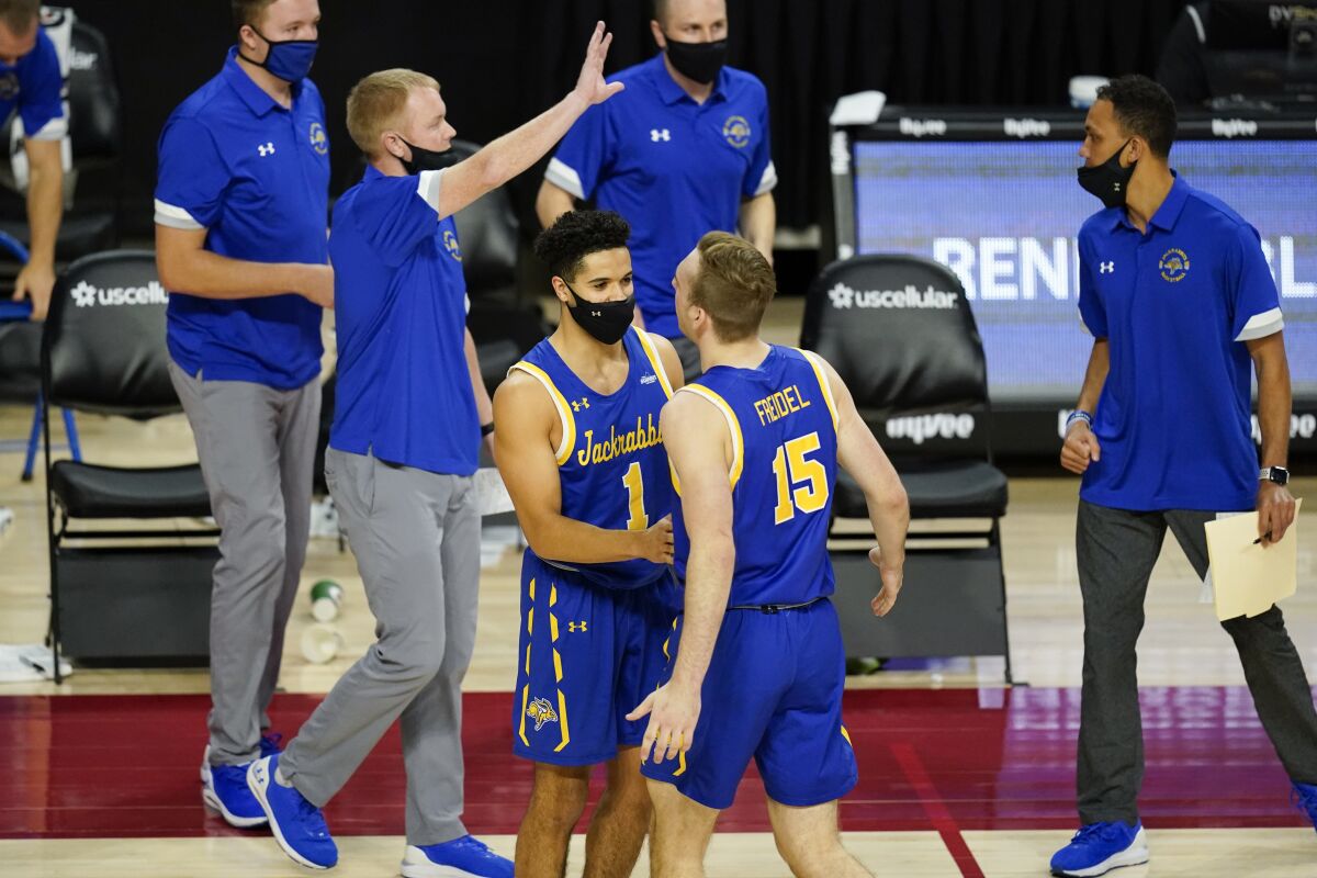 South Dakota State guard Noah Freidel (15) celebrates with teammate Matt Mims (1) at the end of an NCAA college basketball game against Iowa State, Wednesday, Dec. 2, 2020, in Ames, Iowa. South Dakota State won 71-68. (AP Photo/Charlie Neibergall)