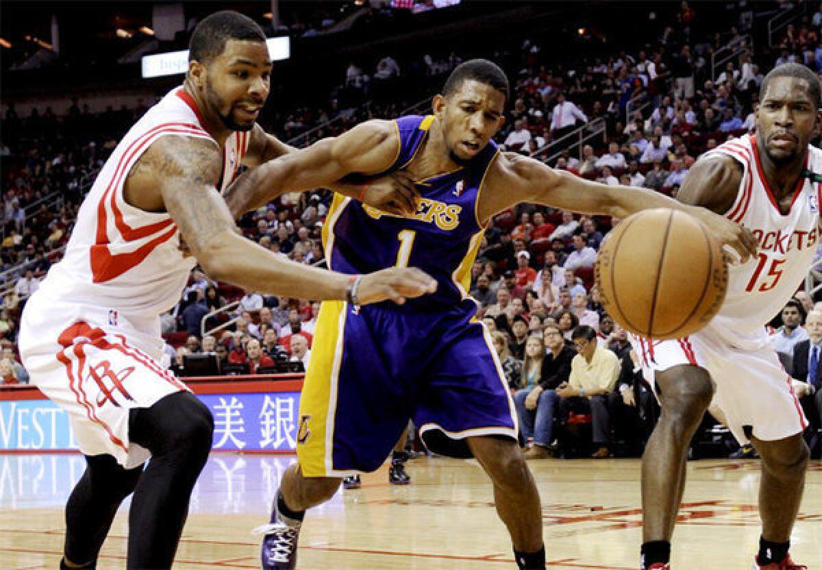 Lakers point guard Darius Morris battles for a loose ball against Houston Rockets forward Marcus Morris and guard Toney Douglas.