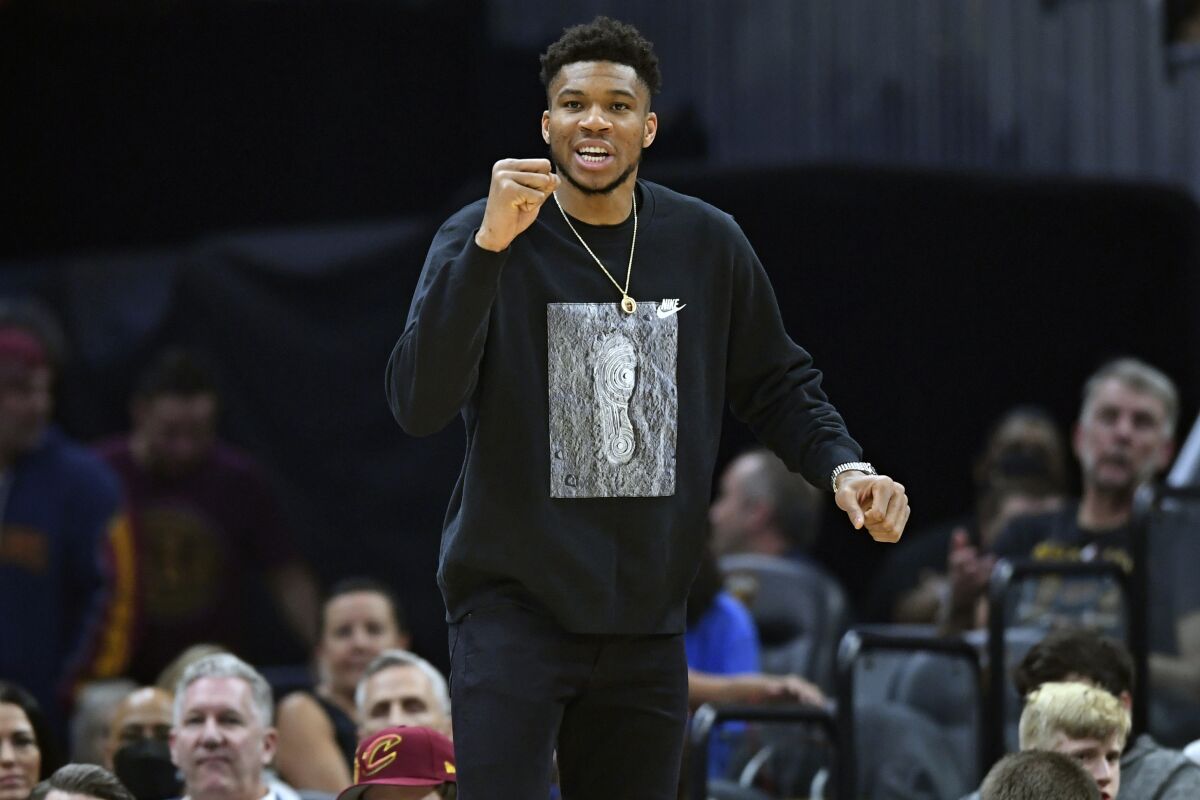 Milwaukee Bucks forward Giannis Antetokounmpo cheers from the bench in the first half of an NBA basketball game against the Cleveland Cavaliers, Sunday, April 10, 2022, in Cleveland. (AP Photo/David Dermer)