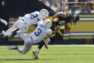 Pittsburgh Steelers tight end Pat Freiermuth, right, is tackled by Los Angeles Chargers safeties Alohi Gilman (32) and Derwin James Jr. during the second half of an NFL football game, Sunday, Sept. 22, 2024, in Pittsburgh. (AP Photo/Matt Freed)