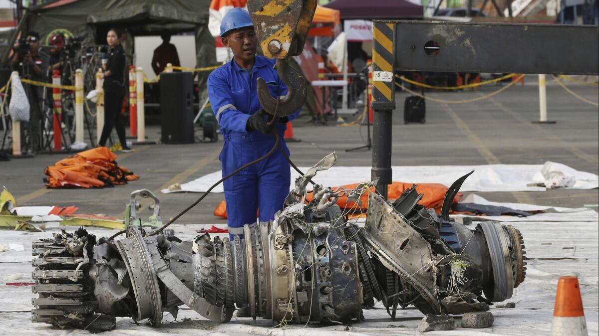 Officials move an engine recovered from the crashed Lion Air jet for further investigation in Jakarta, Indonesia.