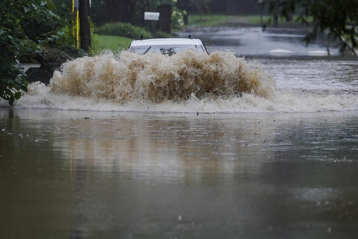 A car attempts to drive through flood waters near Peachtree Creek near Atlanta, as Tropical Storm Fred makes its way through north and central Georgia on Tuesday, Aug. 17, 2021. (AP Photo/Brynn Anderson)