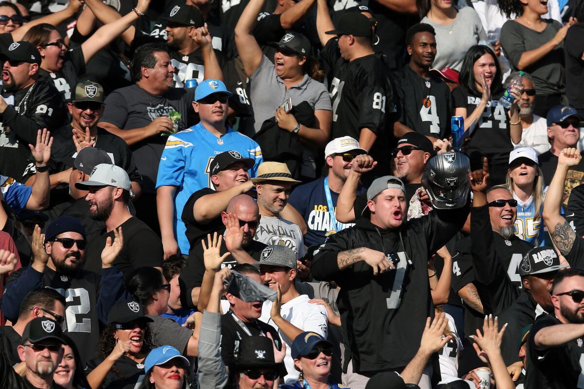 CARSON, CA - DECEMBER 31: A Los Angeles Chargers fan is seen surrounded by Oakland Raiders fans during the first half of the game at StubHub Center on December 31, 2017 in Carson, California.