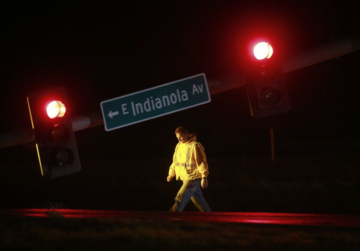 A utility worker tends to a downed stoplight on Highway 69 in Des Moines, Iowa, on Saturday, March 5, 2022, after a strong storm caused damage in areas of central Iowa. (Bryon Houlgrave/The Des Moines Register via AP)