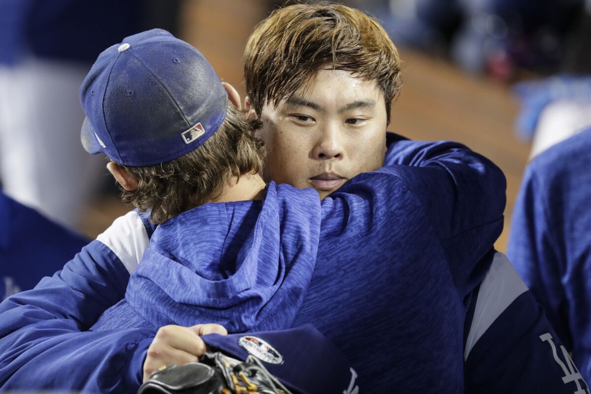Dodgers pitcher Hyun-jin Ryu is embraced by teammate Clayton Kershaw after pitching seven shutout innings against the Braves.