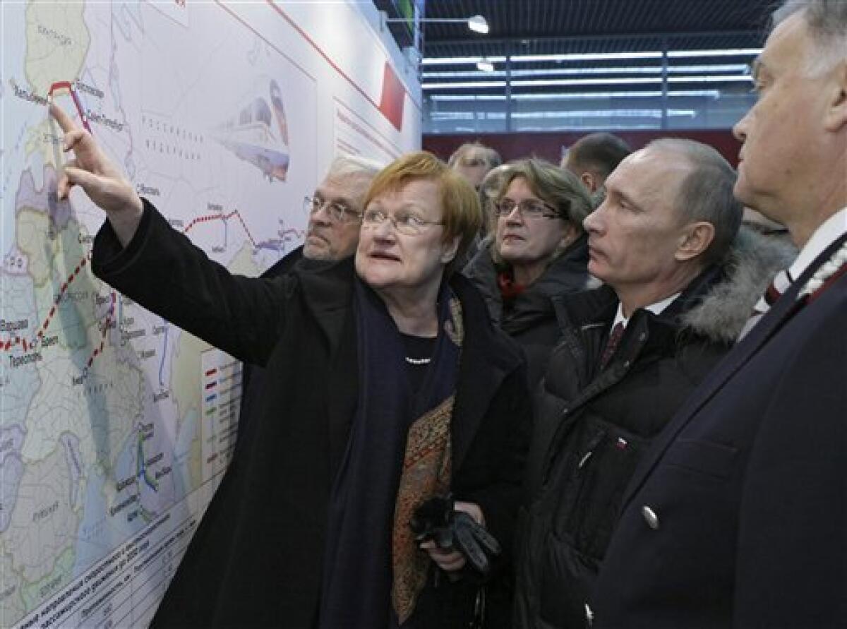 Russian Prime Minister Vladimir Putin, second right, and Finland's President Tarja Halonen, foreground left, look at a map as they arrived by new high speed train in St. Petersburg, Russia, Sunday Dec. 12, 2010. Halonen and Putin inaugurated the first high-speed rail link between the EU and Russia as new trains start running between Helsinki and St. Petersburg, shortening travel time by nearly half, boosting business travel and tourism. At right is Railways Chief Vladimir Yakunin. (AP Photo/RIA Novosti, Alexei Nikolsky, Pool)