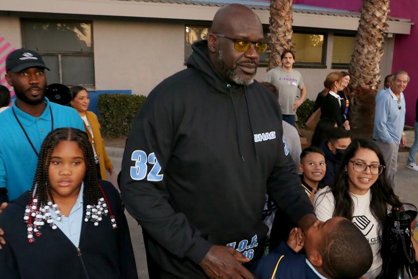 Shaquille O'Neal meets with kids during the unveiling of a new basketball court at the Challengers Boys & Girls Club