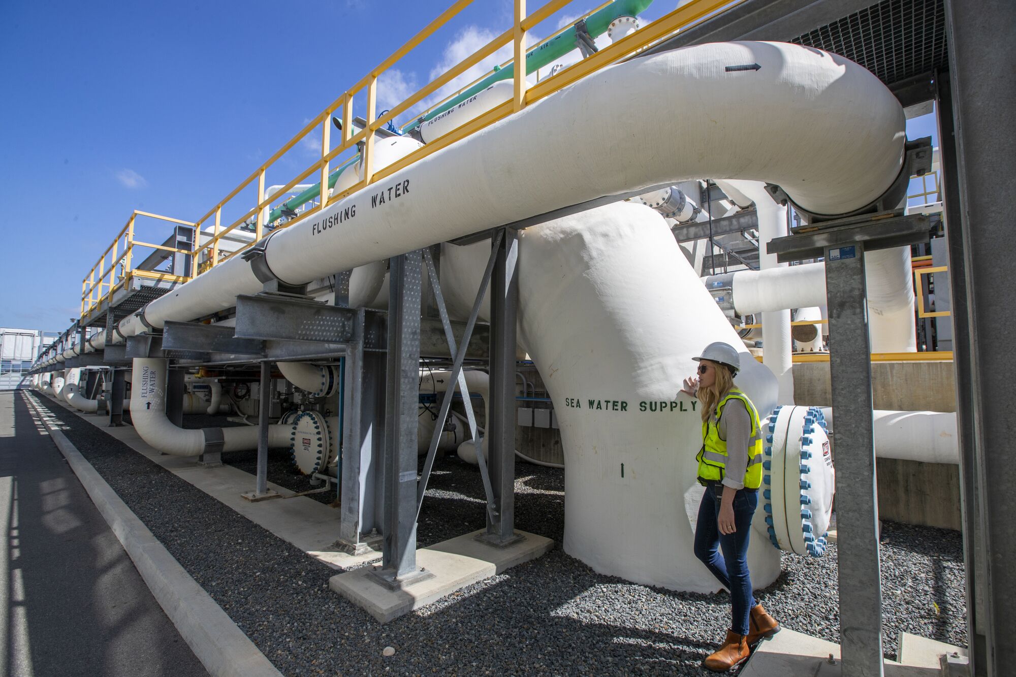 Michelle Peters stands by pipes in the pretreatment section at the Carlsbad desalination plant
