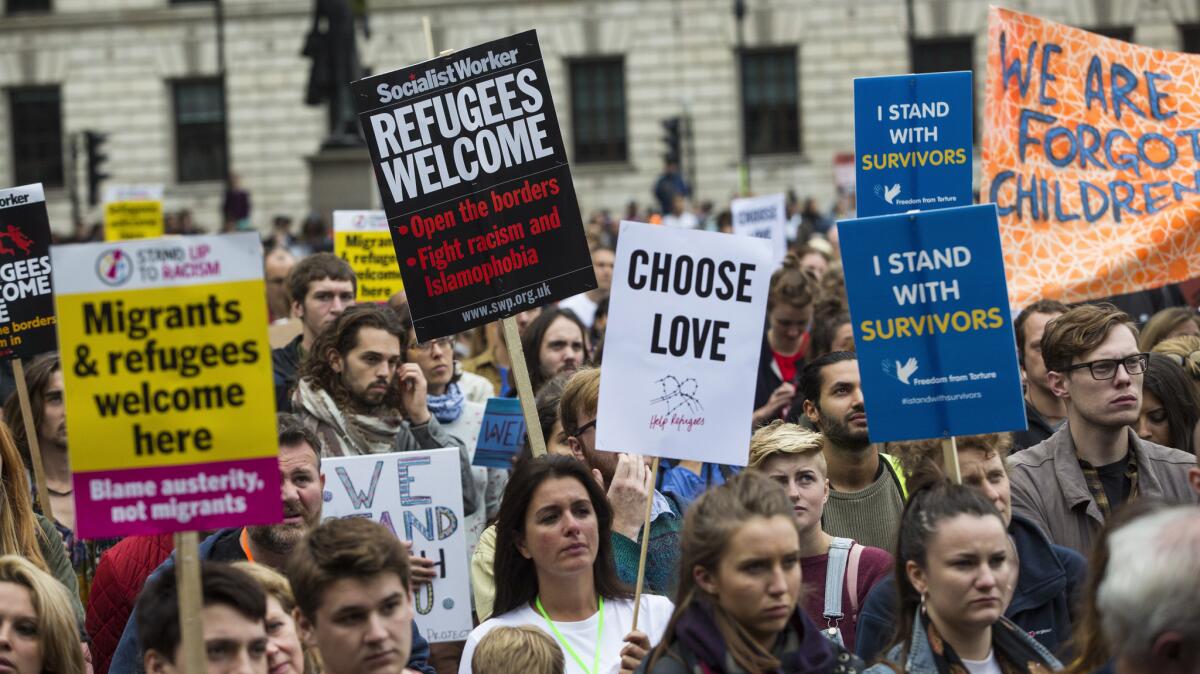 Protesters in London hold placards as they listen to speakers in Parliament Square during a Sept. 17, 2016, demonstration organized by Amnesty International to show support for refugees.