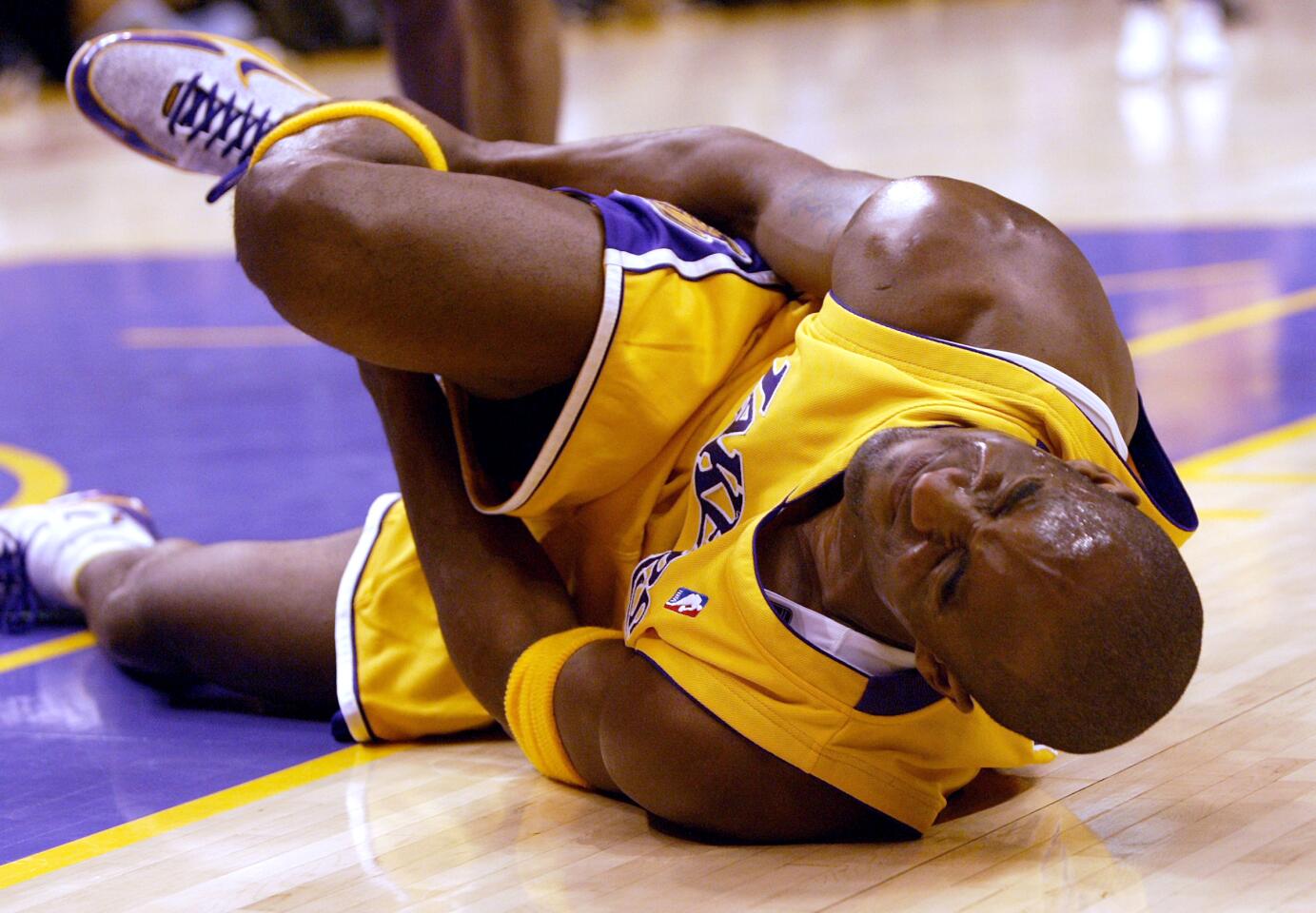 Kobe Bryant down on the court, clutching his right ankle.