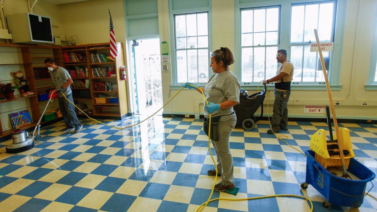 All the furniture must go before the crew of Eloy Avila, Edelmira Lemus and Alberto Castro can dive into the deep cleaning of a room at 49th Street Elementary.