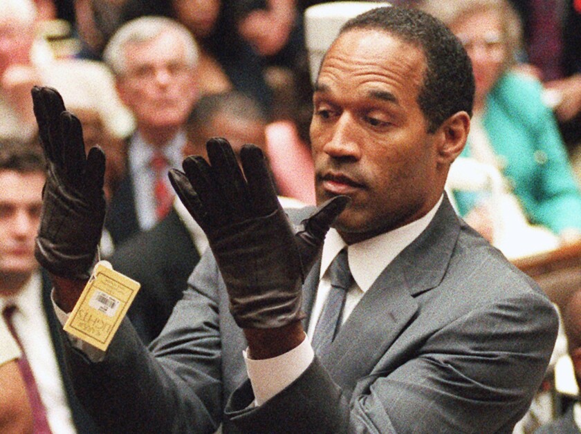 Simpson は、ロサンゼルスでの二重殺人の裁判で、悪名高い血まみれの手袋に似た新しい手袋をはめた後、陪審員の前で手を挙げています。