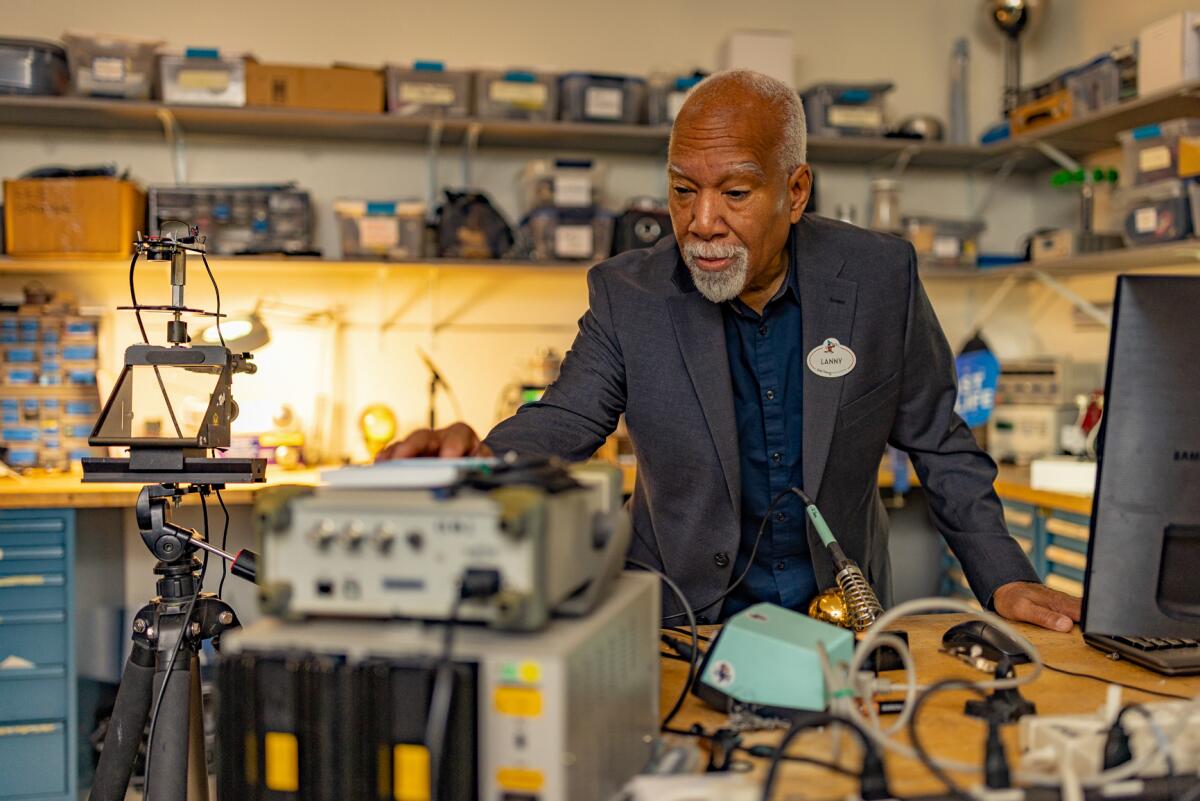 Lanny Smoot working in a laboratory surrounded by machines.