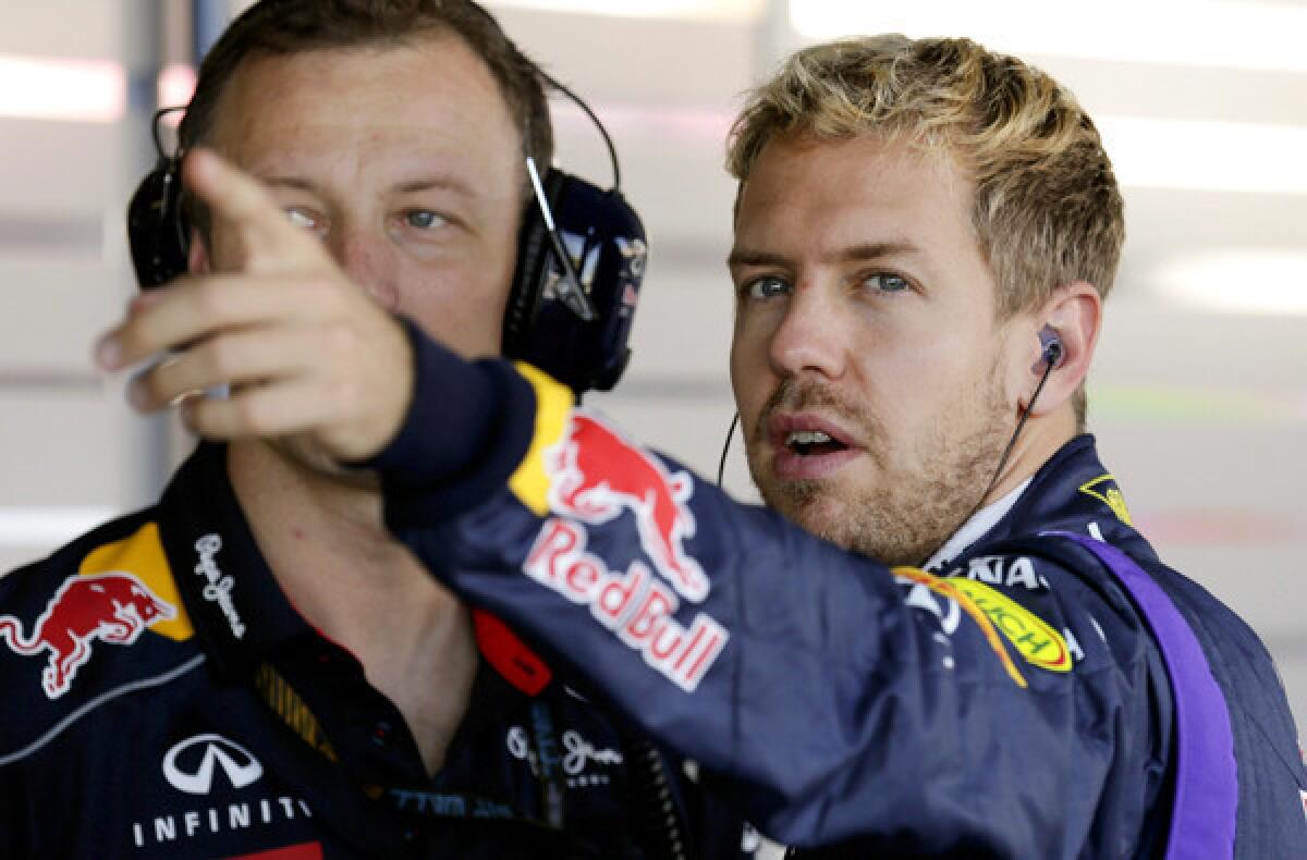 Formula One driver Sebastian Vettel of Red Bull Racing talks with a crew member before the second practice session of the Japanese Grand Prix at Suzuka Circuit.