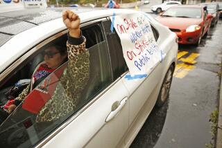 MONTEREY PARK, CA - APRIL 09: Fanny Ortiz, a union organizer raises her fist as she honks her horn joined by a number of vehicles honking their horns while parked in the drive through of the MacDonald's located at 950 W Floral Dr in Monterey Park as non-union employees of various fast food restaurants in Los Angeles staged a "socially distant drive-through strike line" Thursday morning to demand that management do more to keep workers safe during the coronavirus pandemic. The protest was inspired by a series of strikes that began Sunday at a McDonald's in Los Angeles, where a worker tested positive for COVID-19. Employees are demanding masks, gloves, soap, hazard pay and sick days. McDonald's on Thursday, April 9, 2020 in Monterey Park, CA. (Al Seib / Los Angeles Times)