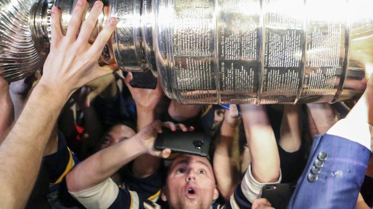 Fans get a close-up view of the Stanley Cup after the Blues arrived at the airport in St. Louis early Thursday morning.