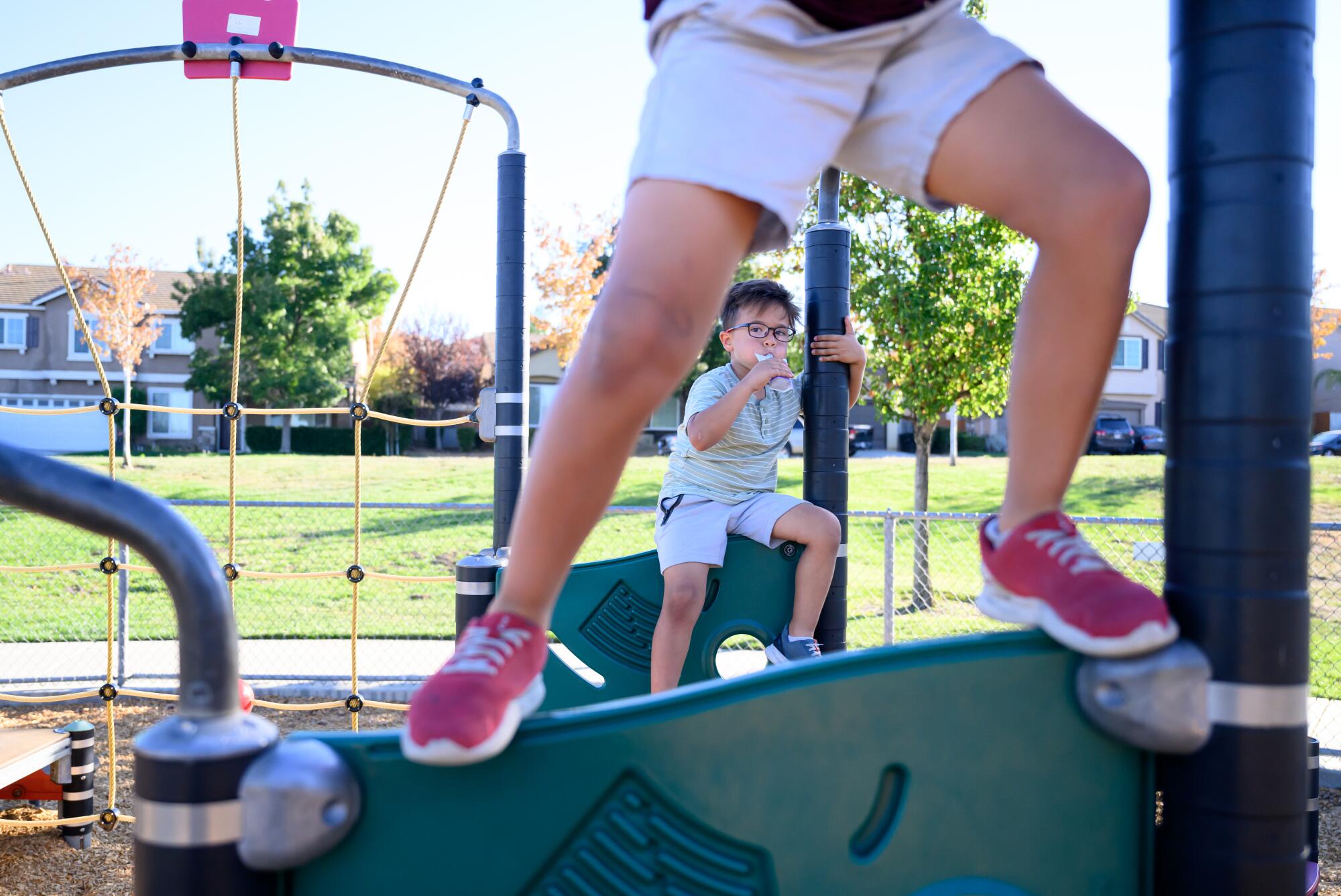 Lucas Martinez eats from a baby food pouch at a park