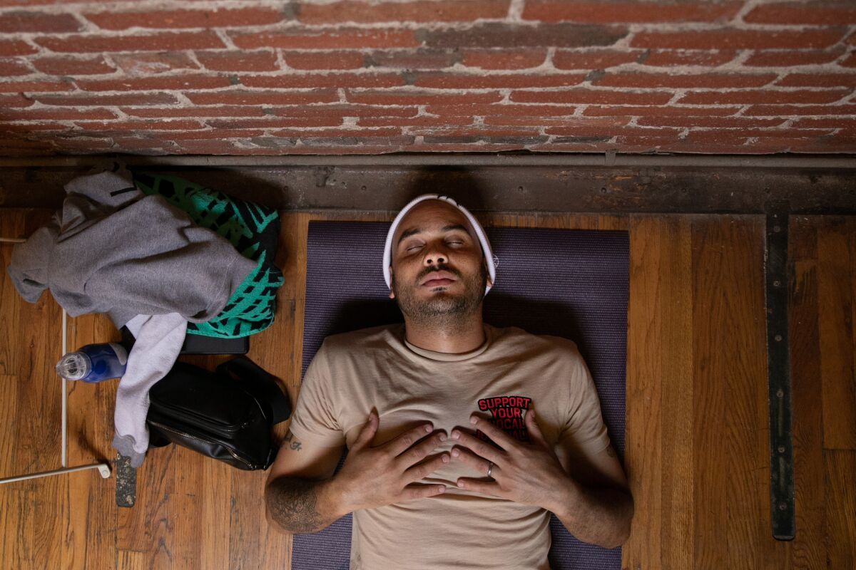 With hands on his chest, Bobby Brown lies down on the floor to meditate.