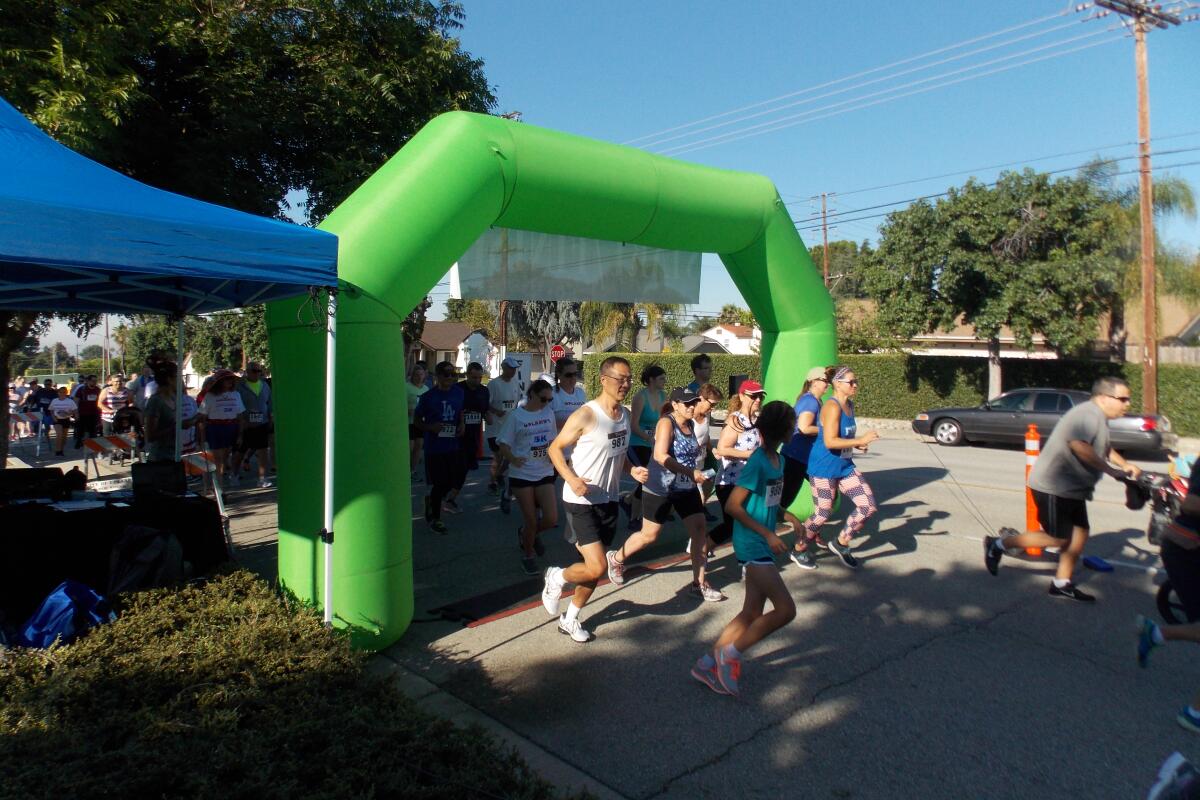 Runners pass under a green inflated start line balloon