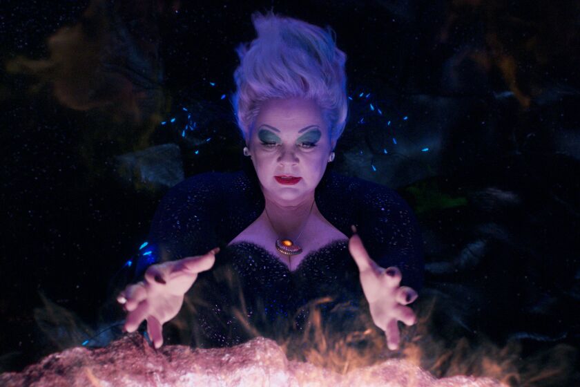 Melissa McCarthy as Ursula holding her hands over a steaming cauldron in a still from 'The Little Mermaid'